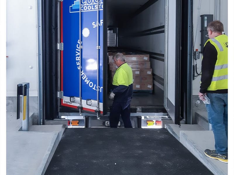 A refrigerated truck backed into a loading dock with a DOBO system.